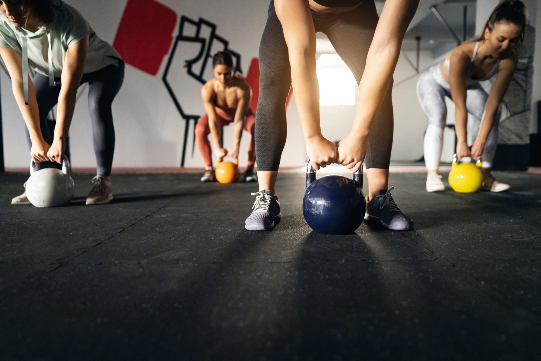 Fitness instructor leading a class with dumbbells in a modern gym