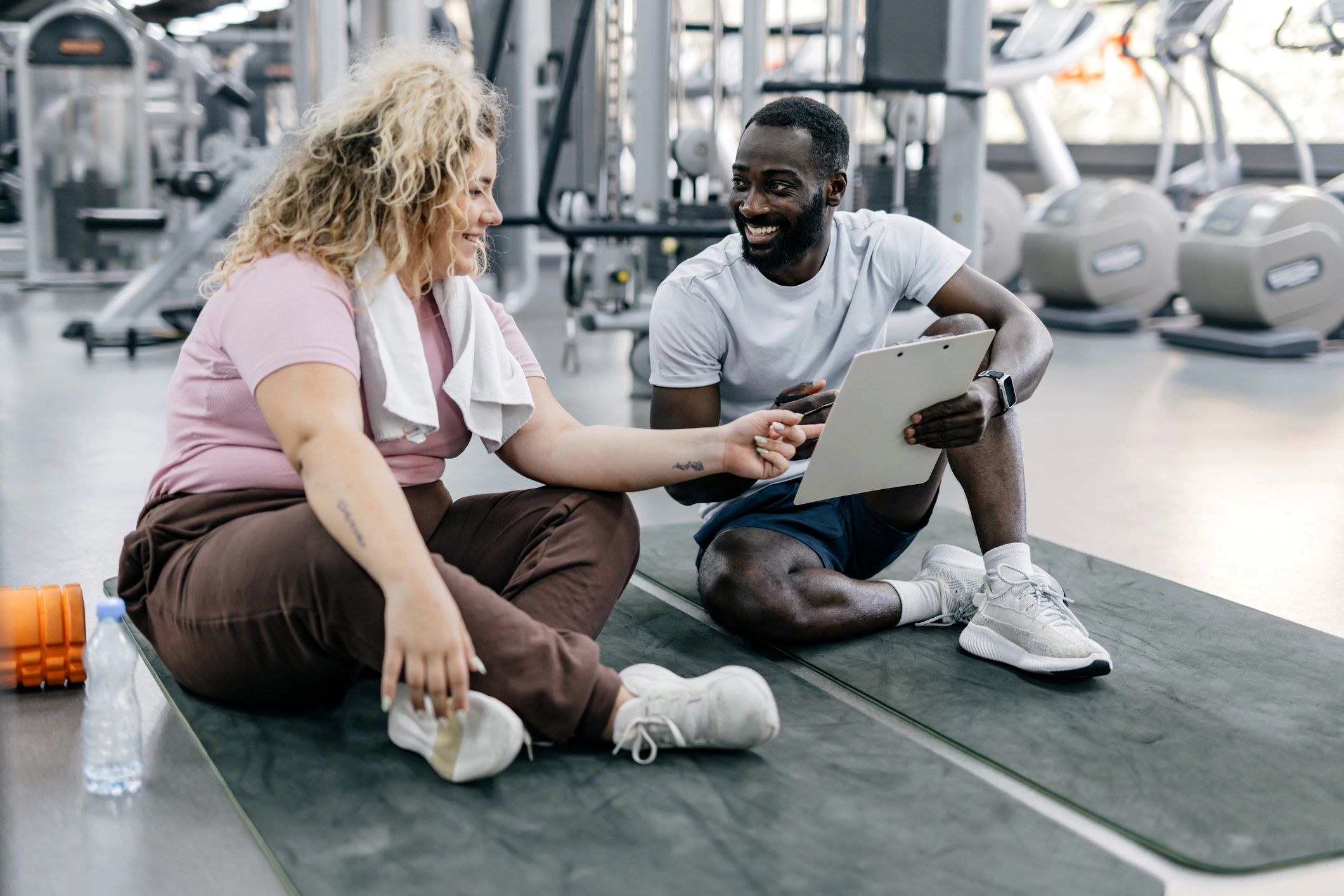 Trainer and trainee discussing workout progress and goals
