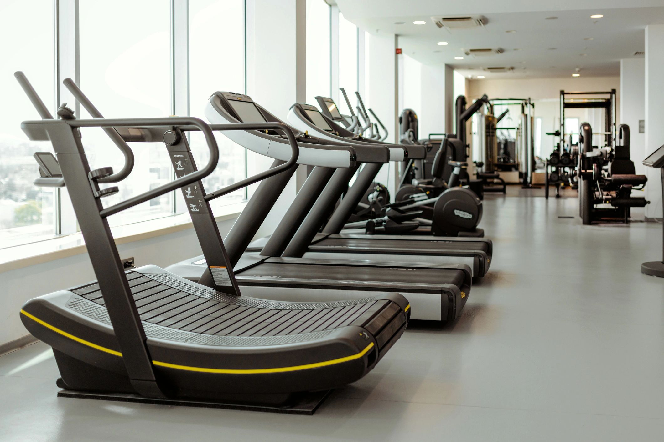 Modern gym interior with cardio equipment and natural light