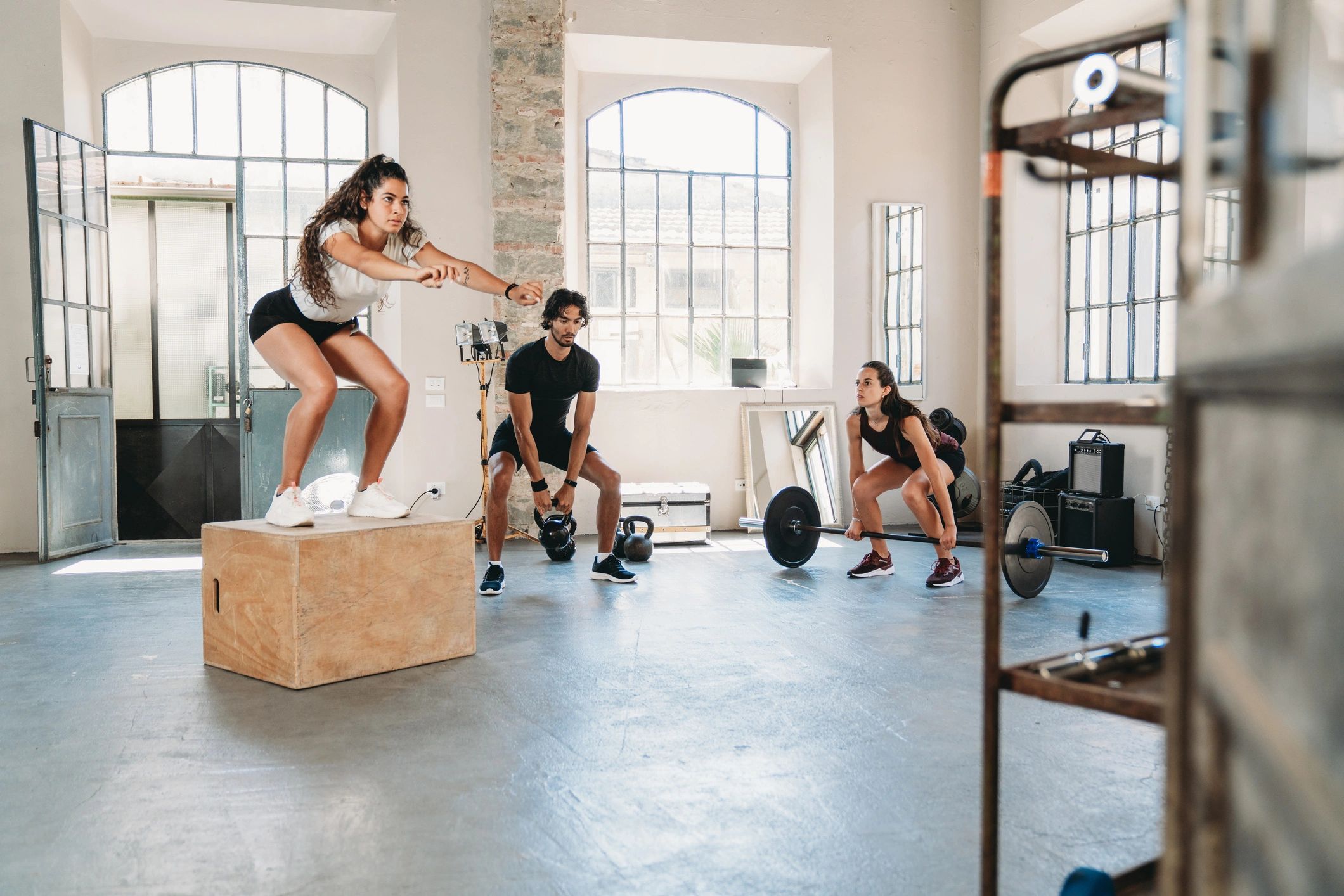 Group training session in a gym with multiple athletes